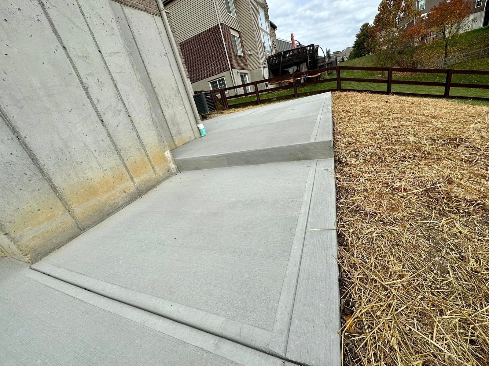 Finished concrete walkway and step at a walkout foundation