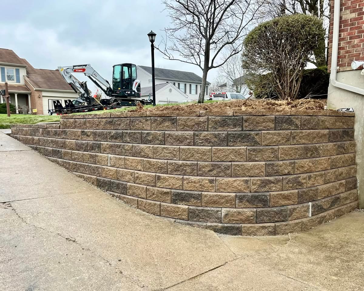 Curved segmental block retaining wall replacement along a driveway