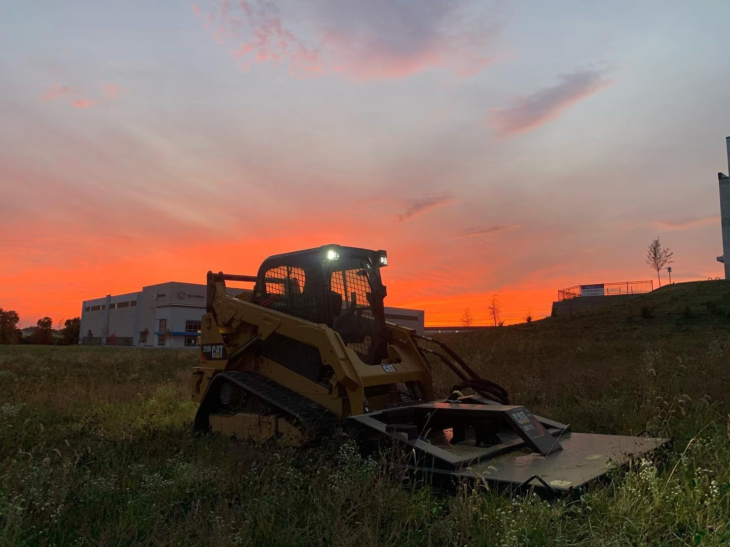 Skid steer clearing land at sunset in Northern Kentucky