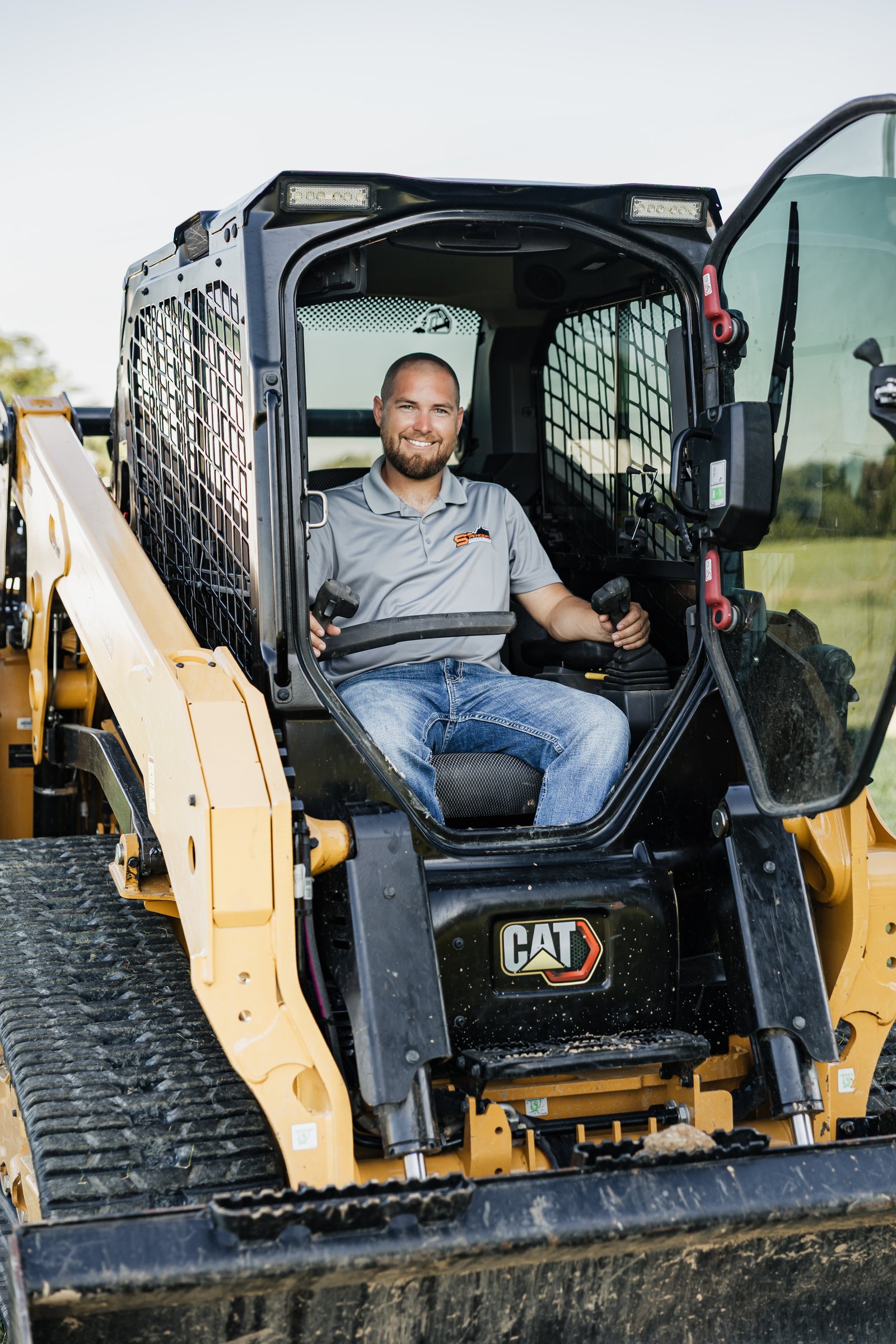 Spencer Stephenson operating a CAT skid steer at a Northern Kentucky jobsite