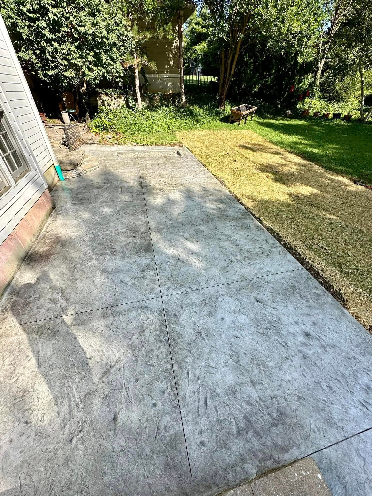 Textured gray stamped concrete patio in a residential rear yard